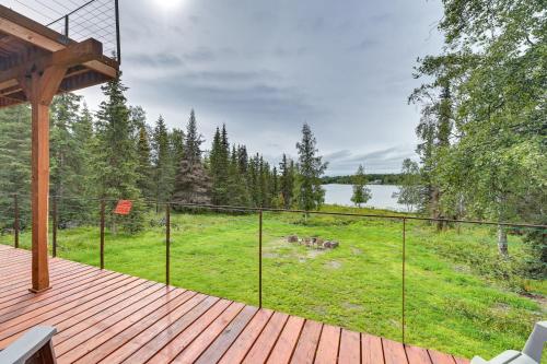 a deck with a fence and animals in a field at Spacious Soldotna Home with Mackey Lake Views! in Soldotna