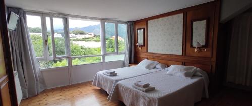 a bedroom with a bed and a large window at Apartamentos El Jornu in Llanes