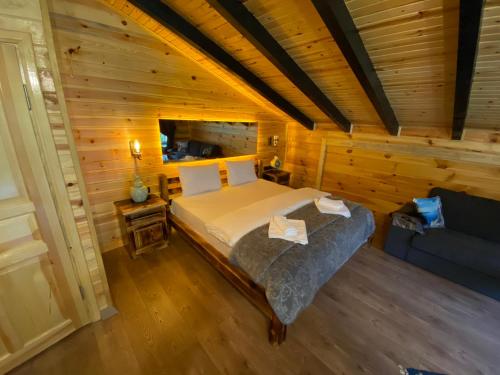 a bedroom in a log cabin with a bed and a couch at Hayvore Loft in Çamlıhemşin