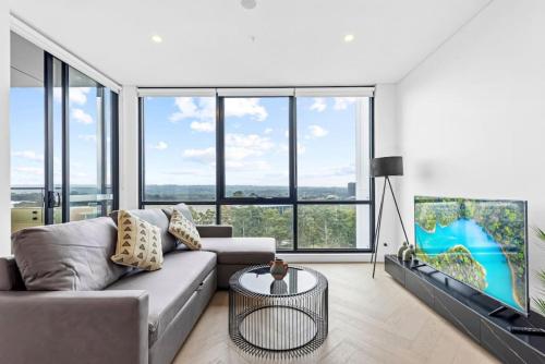 a living room with a couch and some windows at Exquisite High-End Retreat in Macquarie Park in Sydney