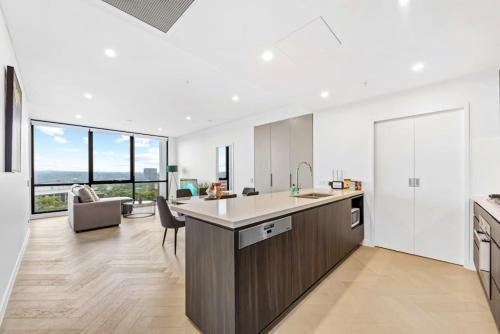an open kitchen and living room with views of the ocean at Exquisite High-End Retreat in Macquarie Park in Sydney