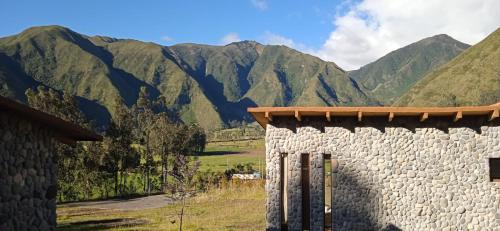 a stone wall with mountains in the background at The Cottage Angochagua in Ibarra