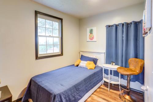ein kleines Schlafzimmer mit einem blauen Bett und einem Stuhl in der Unterkunft Vickery Cottage on Sandusky Bay with Fire Pit! in Port Clinton