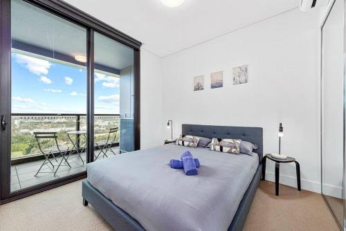 a bedroom with a large bed and a balcony at New Amazing Park City high level APT in Sydney