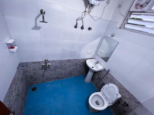 a bathroom with a toilet and a sink and a mirror at Hotel Elite by Agira- Spacious Apartments with Balcony in Yelahanka
