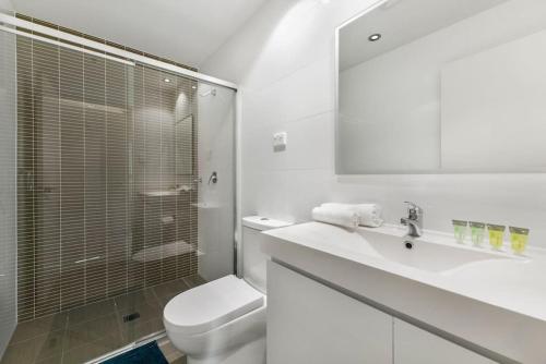 a bathroom with a toilet and a sink and a shower at Spacious 2 beds Apt near Airport in Sydney
