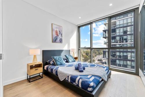 - une chambre avec un lit et une grande fenêtre dans l'établissement Luxury 2BR APT in heart of Macquarie Park, à Sydney