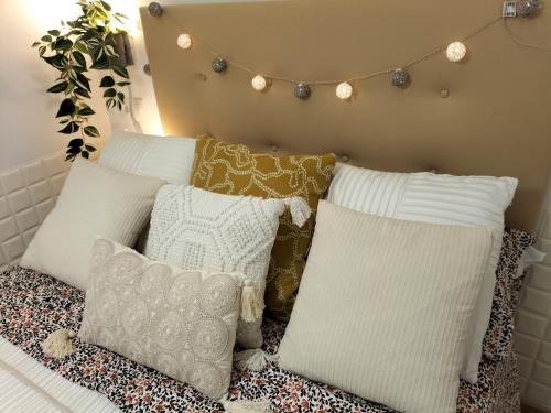 grupa poduszek na łóżku z oświetleniem na ścianie w obiekcie El Majo de Vallecas w Madrycie