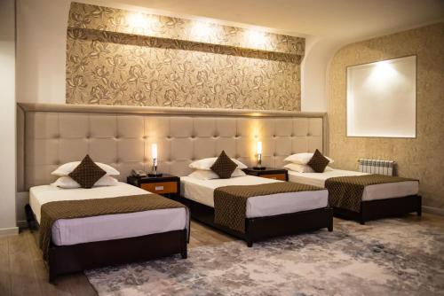 um quarto de hotel com duas camas e um espelho em Hotel Zhibek Zholy em Shymkent