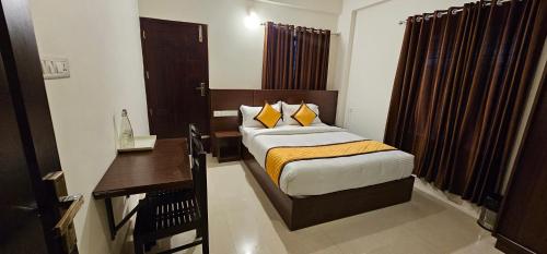 a bedroom with a bed and a desk in a room at BLUEWAY RESIDENCY DOWNTOWN HOTEL in Trivandrum