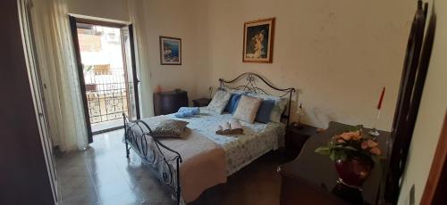 - une chambre avec un lit doté d'oreillers bleus et d'une fenêtre dans l'établissement CASA STELLA, à Savoca