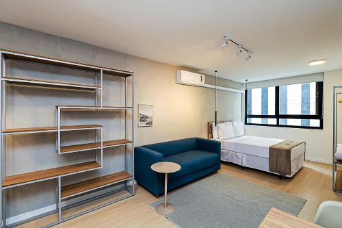 ein Krankenhauszimmer mit einem Bett und einer blauen Couch in der Unterkunft 360 Rio Santos Dumont in Rio de Janeiro