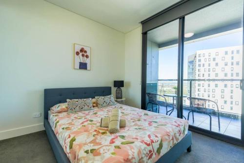 a bedroom with a bed and a large window at Superior View APT in heart of Sydney Olympic Park in Sydney