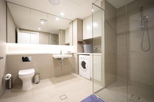 雪梨的住宿－Superior View APT in heart of Sydney Olympic Park，浴室配有卫生间水槽和洗衣机。