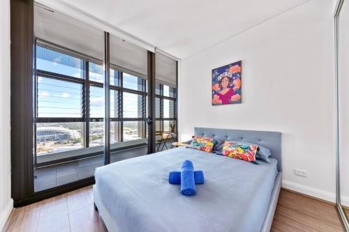a bedroom with a large bed with a blue cross on it at Lovely 2 bedroom APT in centre of Sydney Olympic Park in Sydney
