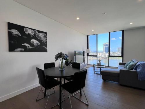 a living room with a table and chairs and a couch at Your Luxury Weekend Getaway in Wentworth Point in Sydney