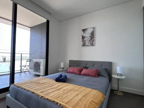 a bedroom with a large bed with red pillows at Your Luxury Weekend Getaway in Wentworth Point in Sydney