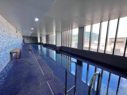 a large swimming pool in a building with windows at Your Luxury Weekend Getaway in Wentworth Point in Sydney