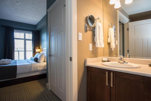 a bathroom with a sink and a bedroom with a bed at Old House Hotel in Courtenay