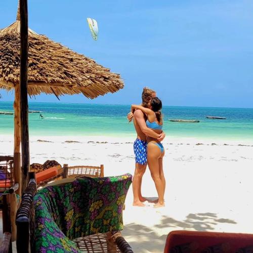a man and a woman standing on a beach at Sipano Beach Lodge Kiwengwa in Kiwengwa