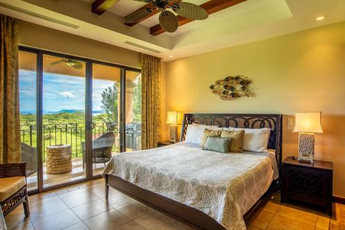 a bedroom with a bed and a balcony at Jobo 1 Luxury Apartment - Reserva Conchal in Playa Conchal