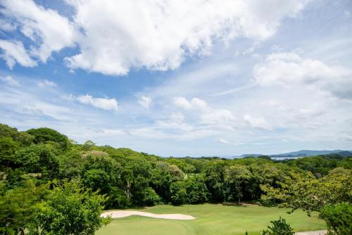 a view of a golf course with trees in the background at Jobo 1 Luxury Apartment - Reserva Conchal in Playa Conchal