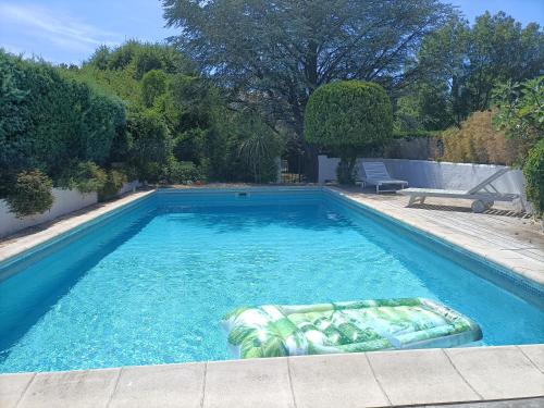 uma piscina num quintal com uma piscina em Maisonnette tout confort em Rochefort-du-Gard
