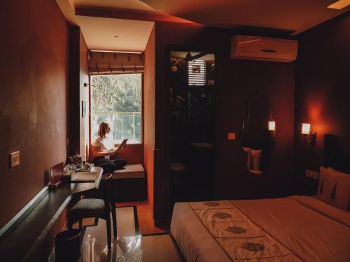 a woman sitting in a window in a hotel room at Ekaa Villa near Taj Mahal in Agra