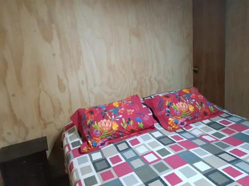 a bed with two pillows on it in a room at Cabaña Tongariki in Hanga Roa