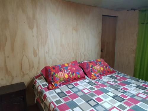 a bed with two pillows on it in a room at Cabaña Tongariki in Hanga Roa