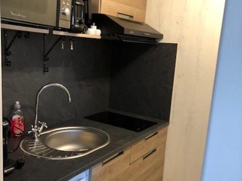un comptoir de cuisine avec un évier et un micro-ondes dans l'établissement Appartement charmant proche plage et commerces - FR-1-712-13, à Villers-sur-Mer