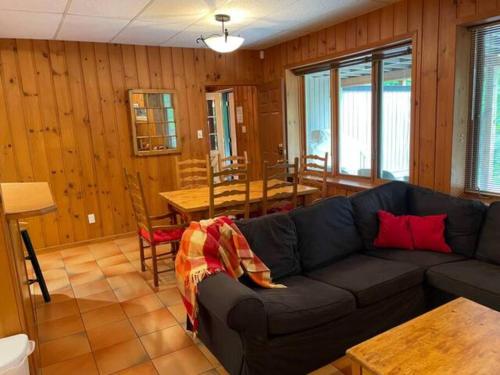 a living room with a couch and a table at 2 bdrm Tremblant Haven-pets & spa-walk/ski to hill in Mont-Tremblant