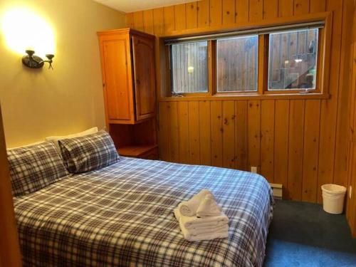 a bedroom with a bed with towels on it at 2 bdrm Tremblant Haven-pets & spa-walk/ski to hill in Mont-Tremblant