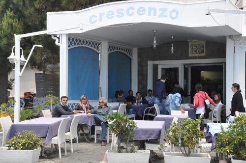 a group of people sitting at tables in front of a building at Hotel Ristorante Crescenzo in Procida