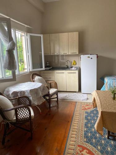eine Küche mit einem Tisch und Stühlen sowie einem Kühlschrank in der Unterkunft Welcome to your home in Green Nature in Rize