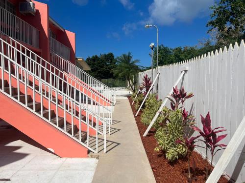 uma cerca branca e escadas ao lado de um passeio em Tropical Hideaway em Nassau