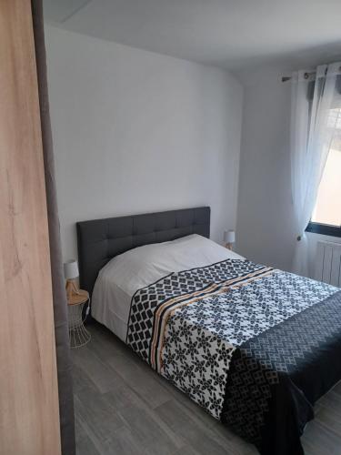 une chambre avec un lit avec une couette dessus dans l'établissement Petite maison cocooning aux portes de Paris, à Orly