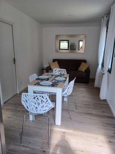a living room with a table and chairs and a couch at Petite maison cocooning aux portes de Paris in Orly