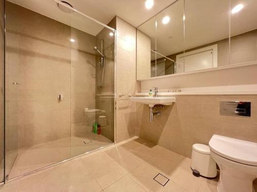 ein Bad mit einer Dusche, einem WC und einem Waschbecken in der Unterkunft Lovely 2 bedroom APT in centre of Olympic Park in Sydney
