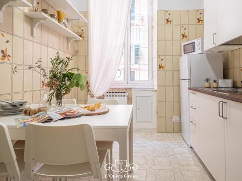 uma cozinha com uma mesa e um frigorífico branco em Casa MaNa - L'Opera Group em La Spezia