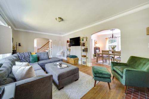 a living room with a gray couch and green chairs at Historic Detroit Bungalow Pet and Family Friendly in Detroit