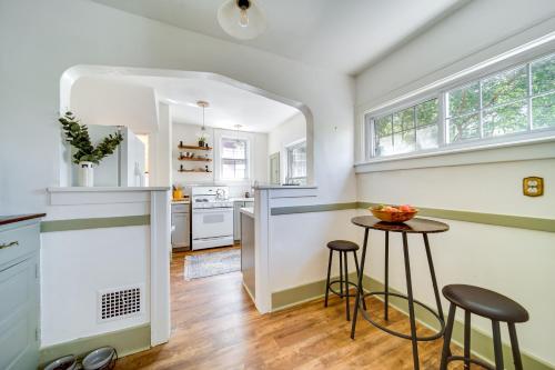a kitchen with white walls and a counter with stools at Historic Detroit Bungalow Pet and Family Friendly in Detroit
