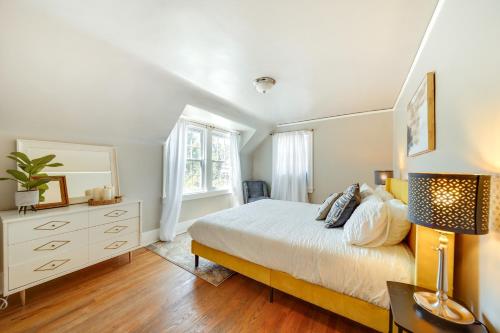 a bedroom with a bed and a dresser and a mirror at Historic Detroit Bungalow Pet and Family Friendly in Detroit