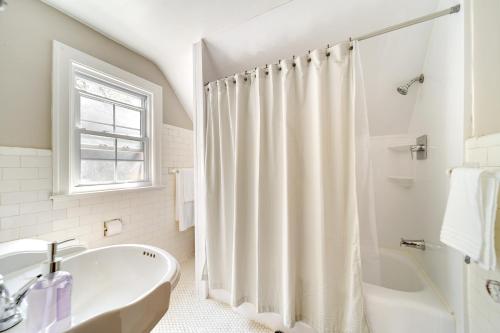 een witte badkamer met een bad en een wastafel bij Historic Detroit Bungalow Pet and Family Friendly in Detroit