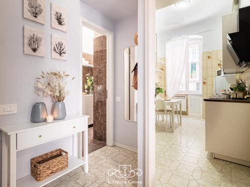 una cucina con bancone bianco e una sala da pranzo di Casa MaNa - L'Opera Group a La Spezia