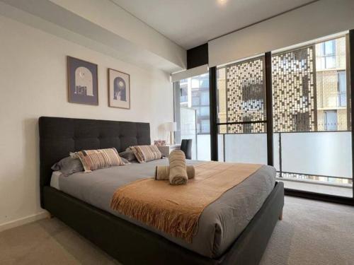 a bedroom with a large bed with a large window at Luxury 2 bedroom APT in Wentworth Point in Sydney