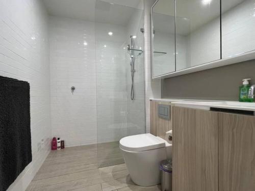a white bathroom with a toilet and a sink at Luxury 2 bedroom APT in Wentworth Point in Sydney