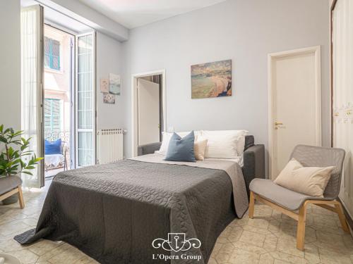 1 dormitorio con 1 cama y 1 silla en Casa MaNa - L'Opera Group, en La Spezia