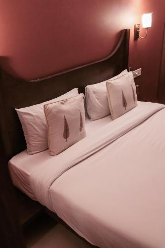 a bed with white sheets and pillows in a room at Ekaa Villa near Taj Mahal in Agra