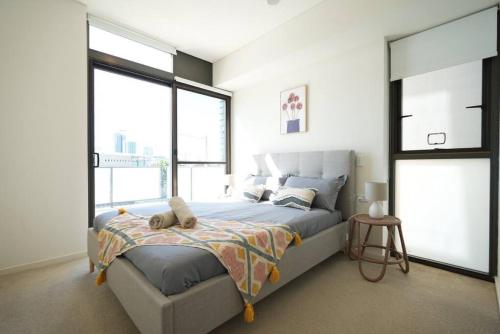 um quarto com uma cama grande e janelas grandes em Stunning 2 bedroom APT in Wentworth point em Sidney